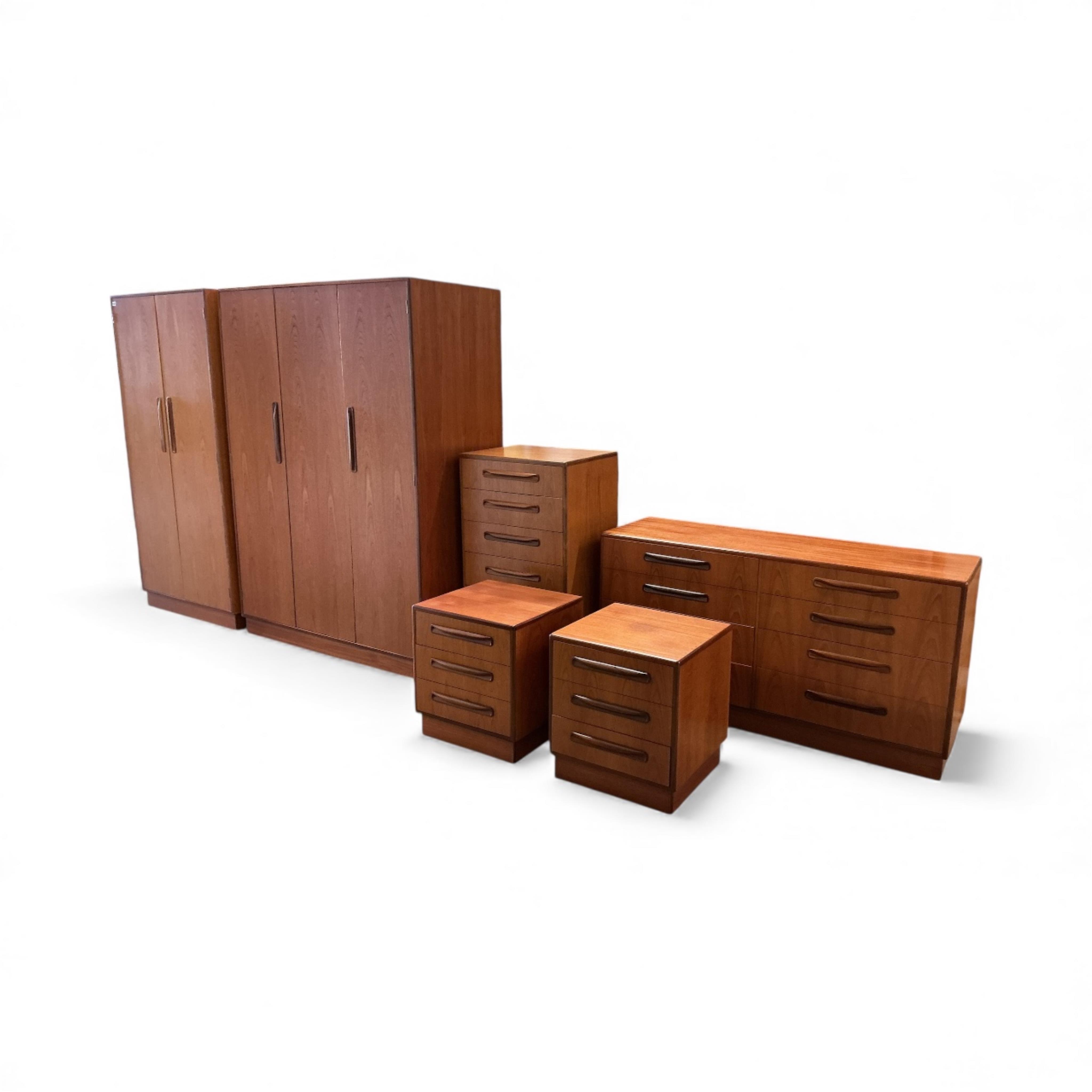 A mid century G Plan Fresco teak bedroom suite comprising a three door wardrobe, a two door wardrobe, two six drawer chests, dressing table, headboard and a pair of bedside chests